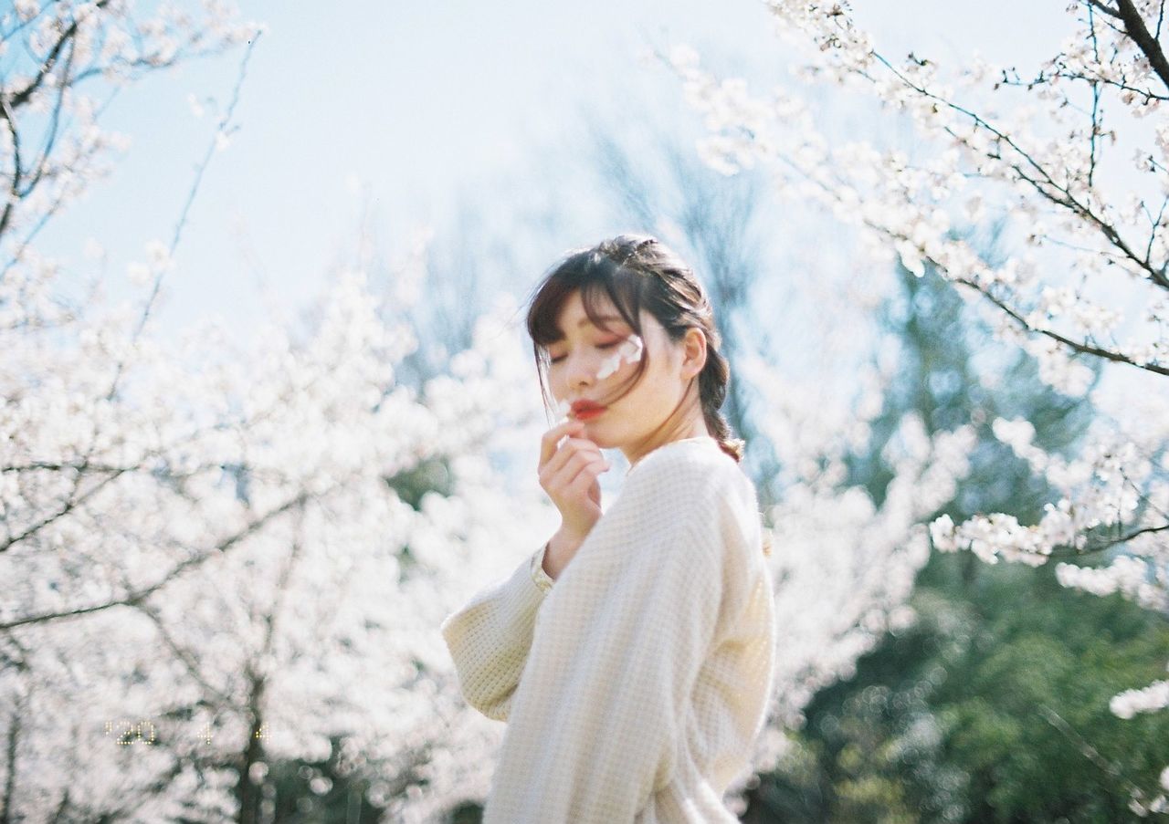 YOUNG WOMAN LOOKING AWAY WHILE STANDING ON SNOW