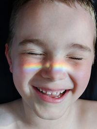 Close-up of smiling boy with eyes closed