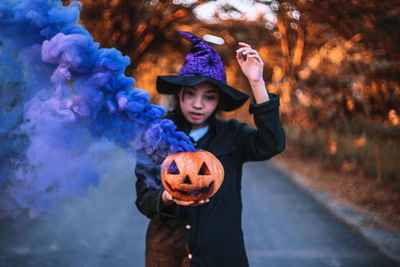 Portrait of boy holding ice cream standing at halloween