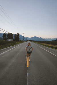 Rear view of woman riding motorcycle on road against sky