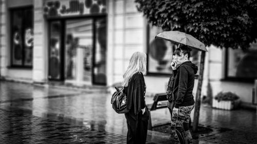 Full length of people with umbrella on wet rainy season