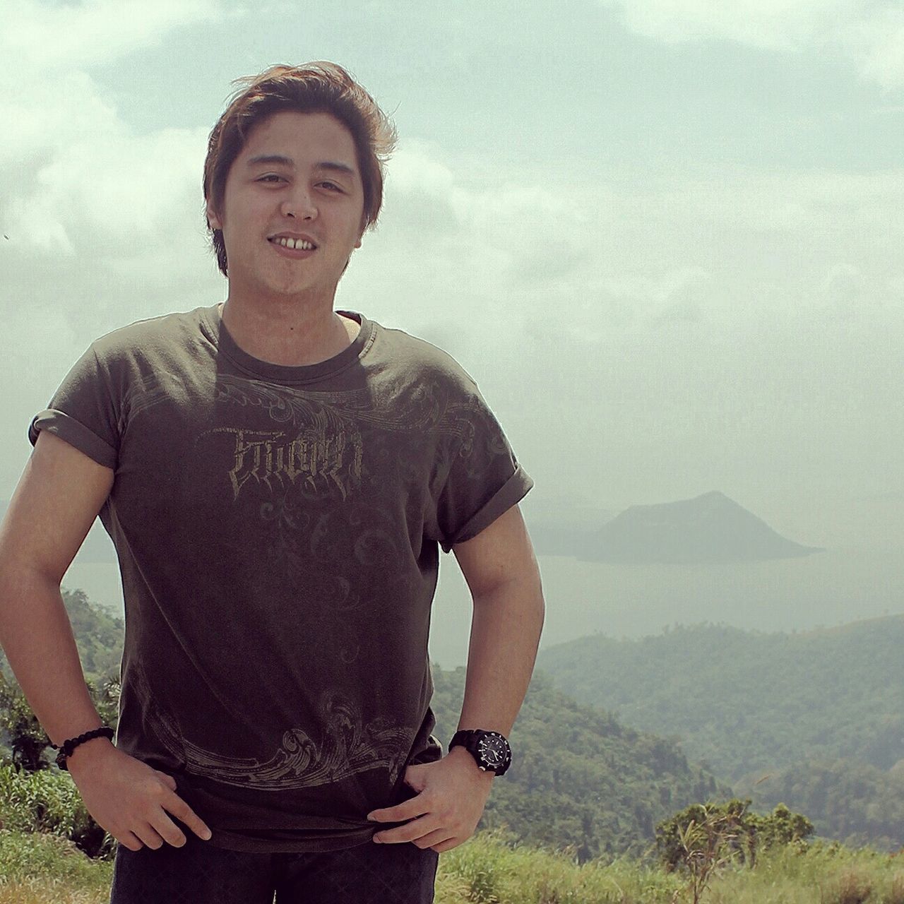 person, lifestyles, casual clothing, leisure activity, young adult, looking at camera, mountain, sky, standing, three quarter length, portrait, young men, front view, full length, cloud - sky, smiling, nature