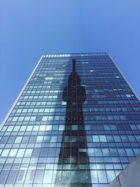 Low angle view of skyscraper against clear blue sky