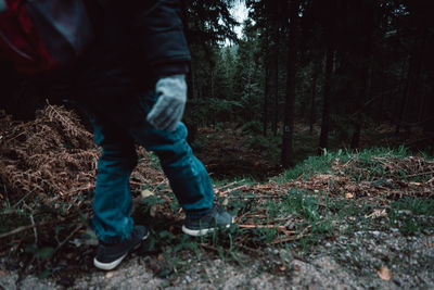 Low section of man standing in forest