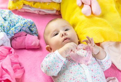 High angle view of cute baby girl lying on bed at home