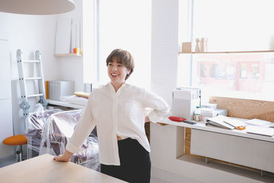 Portrait of a smiling young woman standing on table