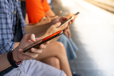 Midsection of man using mobile phone