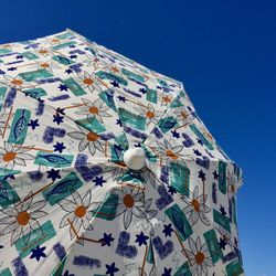 Low angle view of decoration hanging against clear blue sky