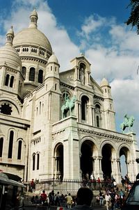 Tourists in front of church against sky