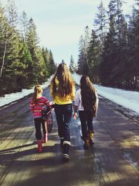 Rear view of woman standing on tree trunk