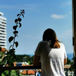 Rear view of woman standing against sky