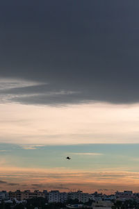 Silhouette of city against sky during sunset