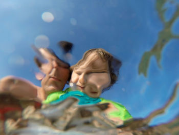 Close-up of boy in swimming pool against blue sky