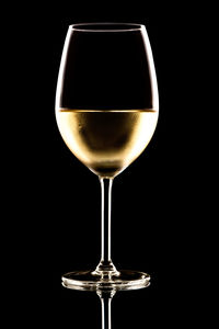 Close-up of wineglass against black background