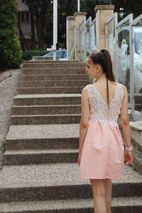 Full length of woman standing on staircase