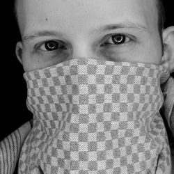 Close-up portrait of man with dish towel over face