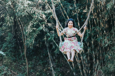 Young pretty asian woman is swinging on the cliff of the jungle in ubud, bali.