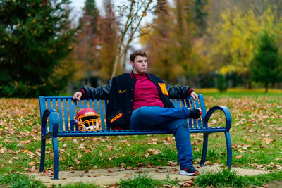 Young woman sitting on bench in park