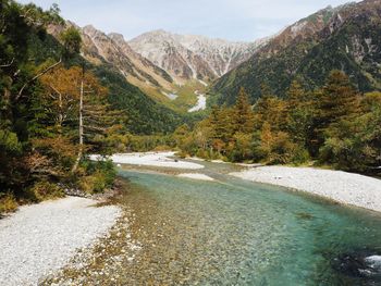 Scenic view of lake by mountains against sky