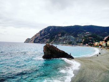 Scenic view of sea by cliff against sky