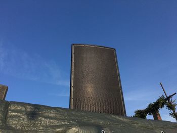 Low angle view of modern building against blue sky