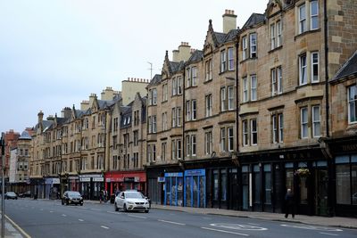 City street by buildings against sky