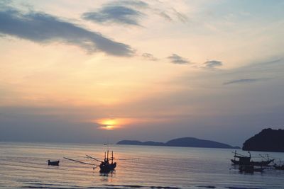 Boat sailing in sea at sunset