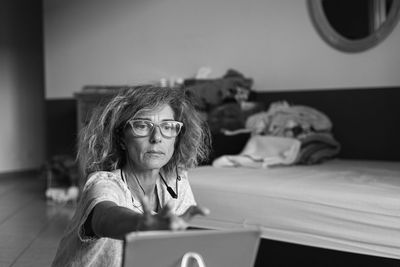 Portrait of woman sitting on table at home