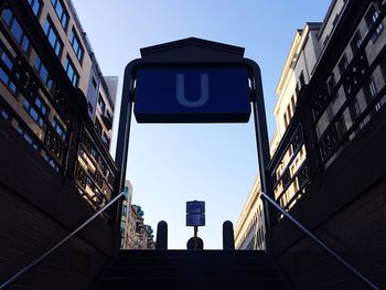 Low angle view of stairway amidst buildings against sky