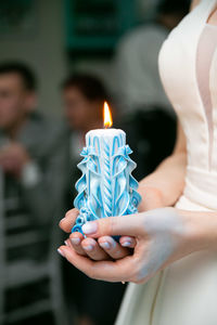 Midsection of woman holding burning candles