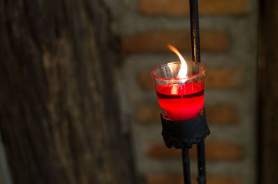 Close-up of illuminated tea light candle on holder