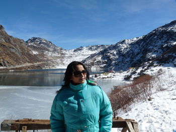 Close-up of woman standing by lake standing against lake during winter