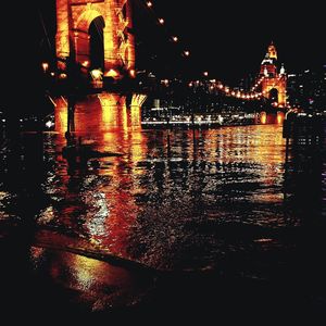 Illuminated buildings by river at night