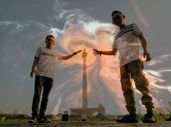 Digital composite image of men standing against sky