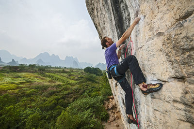 Man climbing on the limestone cliff "white mountain" in yangshuo