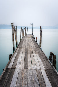 Wooden pier over sea against sky