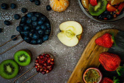 High angle view of fruit assortment in on table in bowl and on cutting board