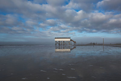 Lifeguard hut on beach against sky