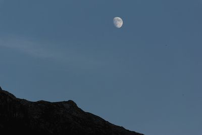 Low angle view of moon against clear blue sky
