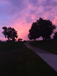 Silhouette trees on landscape against sky at sunset