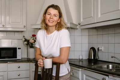 Young woman at kitchen posing looking at camera