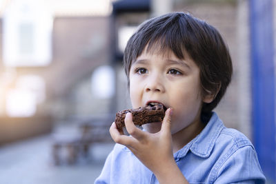 Close-up of cute boy eating cake