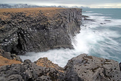 Scenic view of rocks in sea against sky