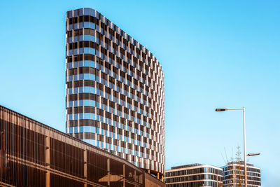 Low angle view of modern buildings against clear blue sky