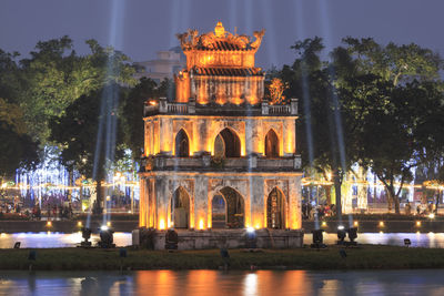 Illuminated turtle tower on hoan kiem lake at dusk