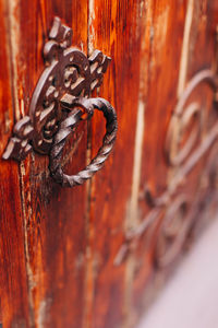 Close-up of rusty chain hanging on metal door