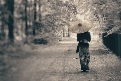 Rear view of woman walking on field