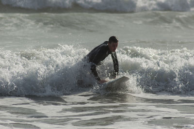 Full length of man splashing water in sea