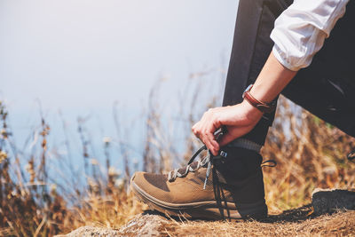 Low section of woman tying shoelace