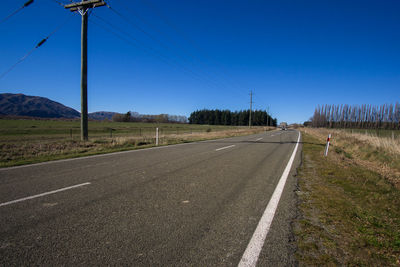 Road against clear blue sky